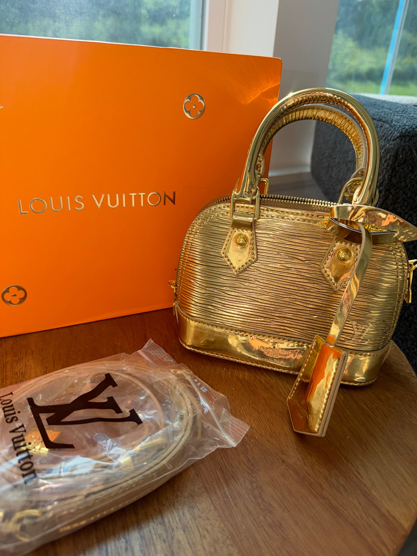 Bolsa dorada Louis Vuitton con accesorios, caja y cubre polvo