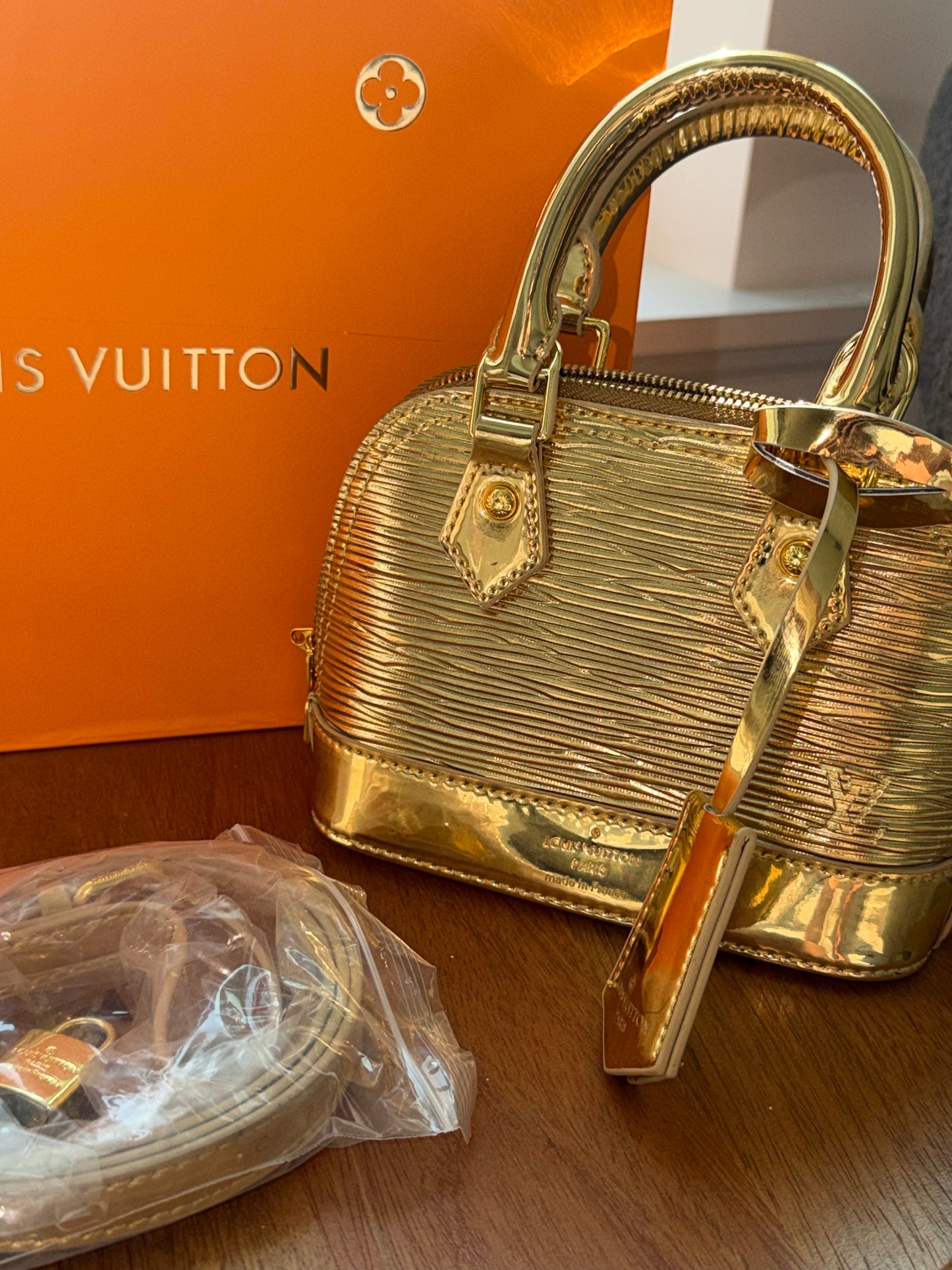 Bolsa dorada Louis Vuitton con accesorios, caja y cubre polvo