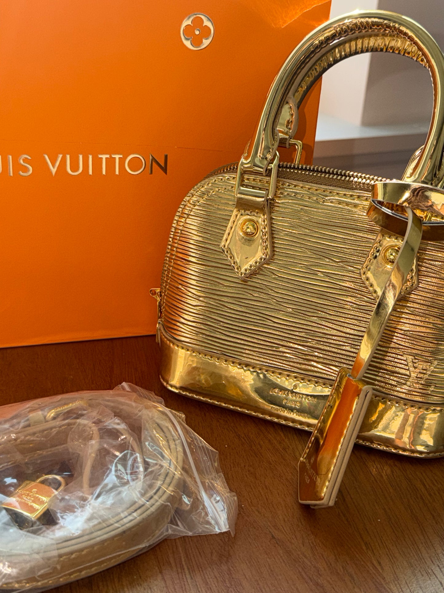 Bolsa dorada Louis Vuitton con accesorios, caja y cubre polvo